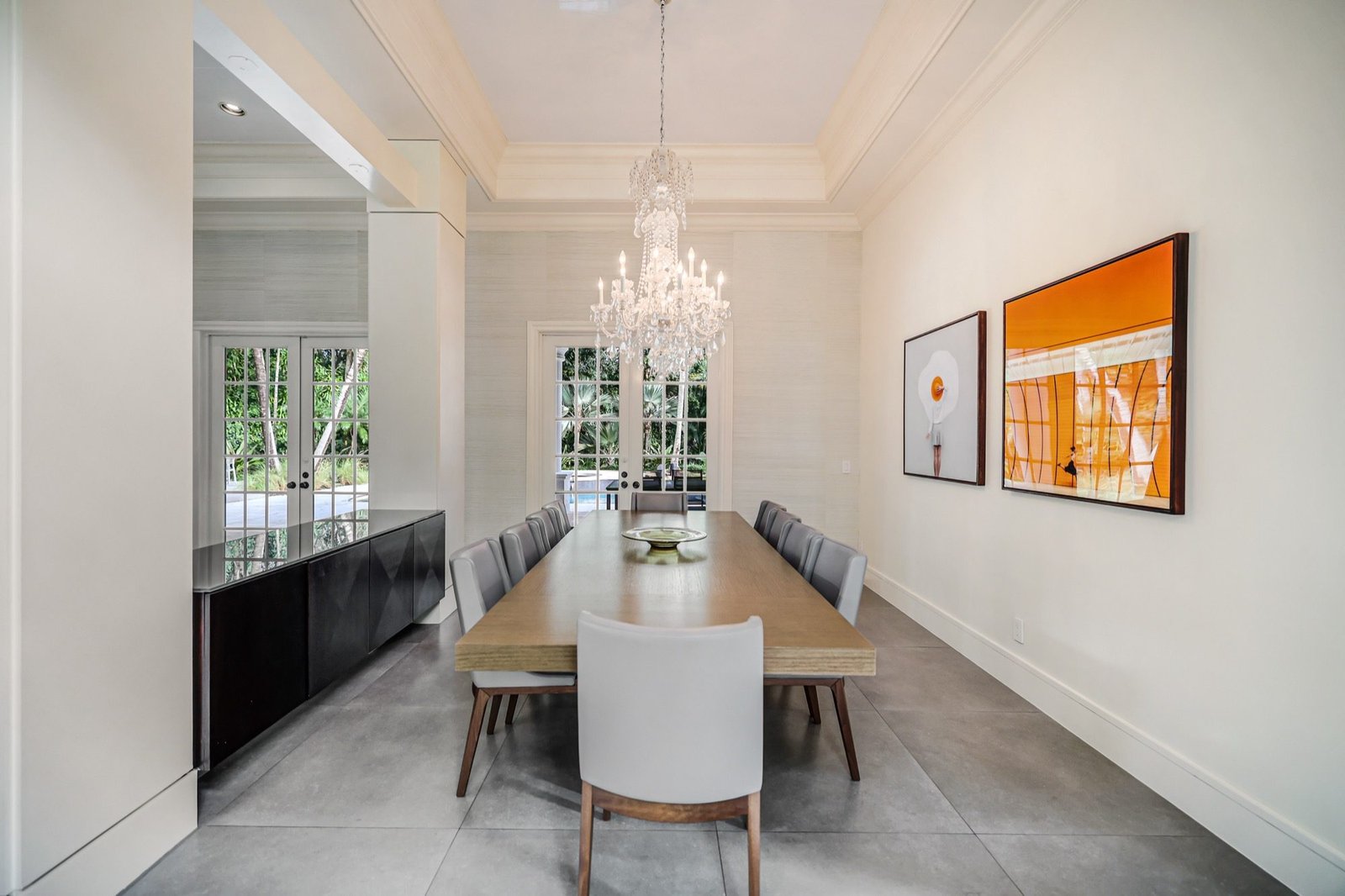 Formal dining room with a crystal chandelier and grasscloth walls