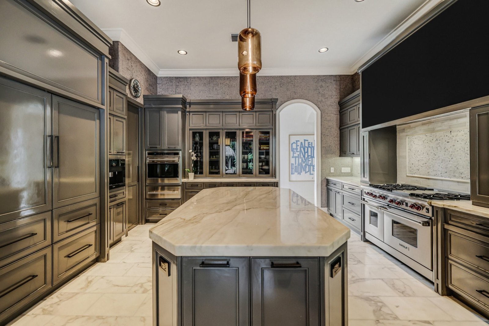 Chef's kitchen with a marble island, Wolf range and custom cabinetry
