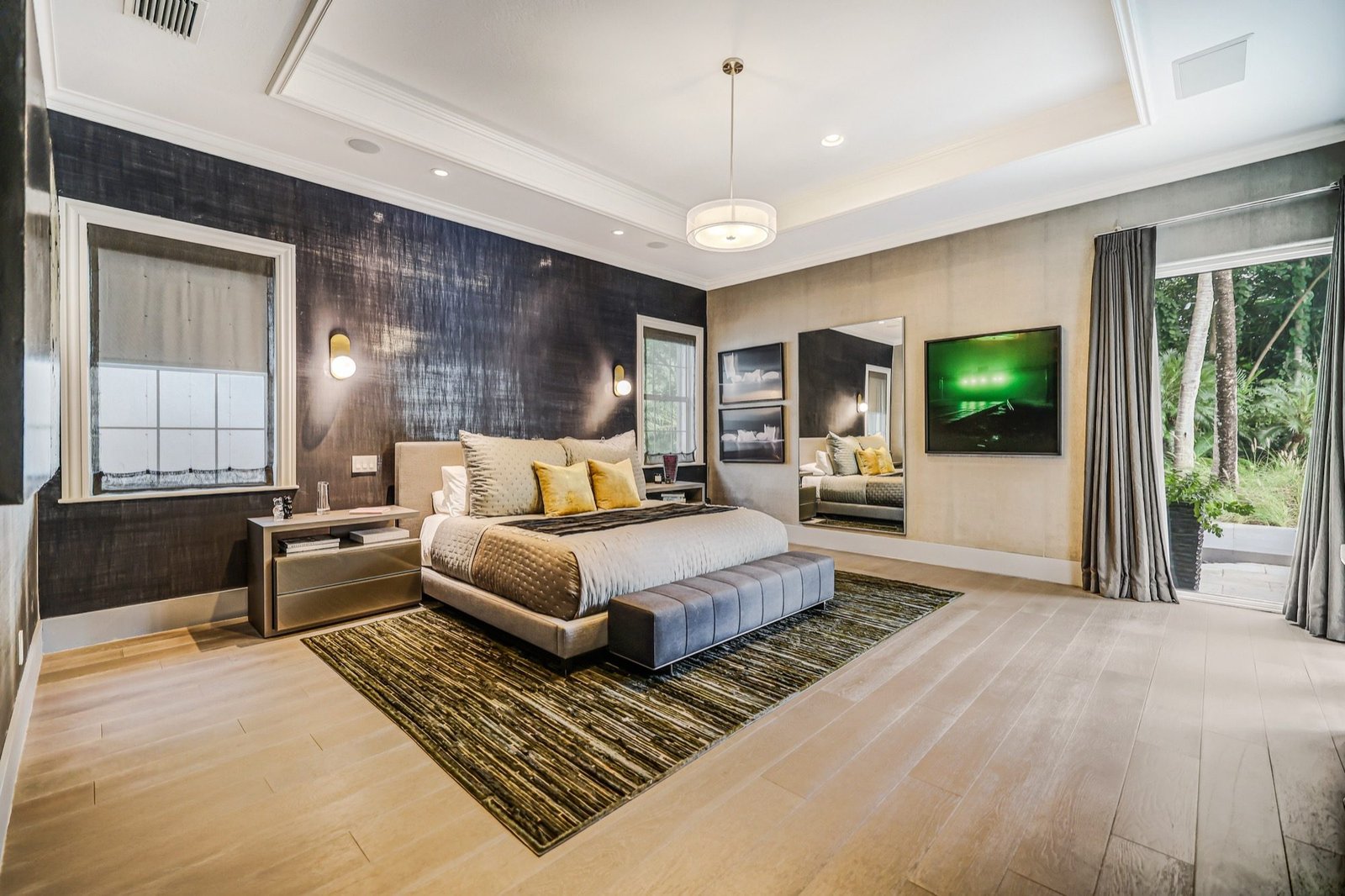 Primary bedroom with a textured feature wall and wide-plank floors